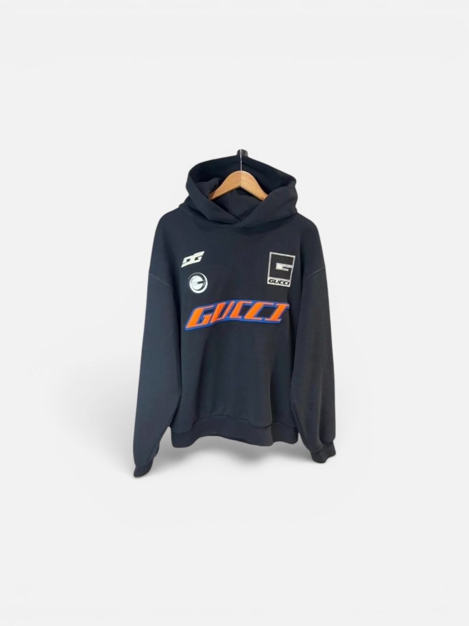 Detailed view of the multi-color racing patches on a black Gucci hoodie.
