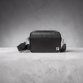 Model wearing Fendi black leather camera bag with FF motif panel.