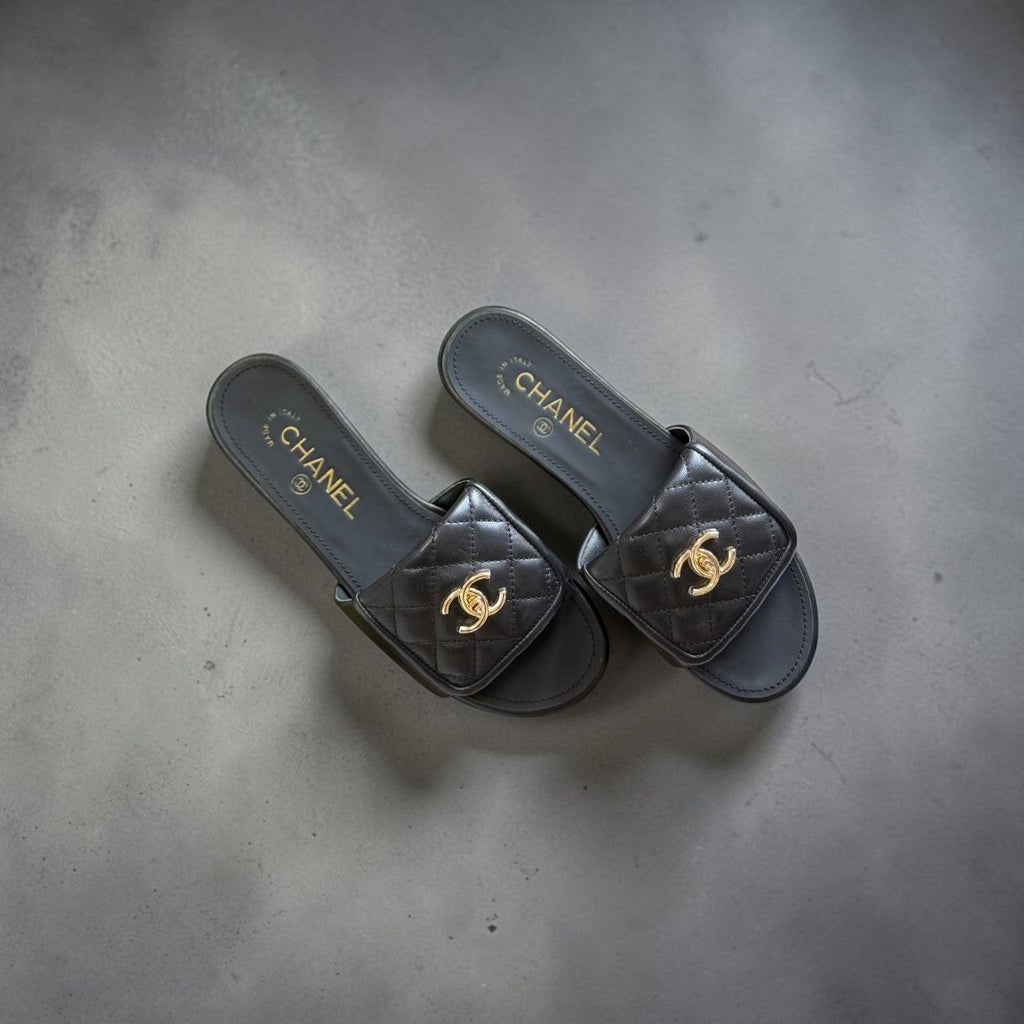 Top view of black Chanel quilted lambskin mules with gold CC logo.