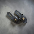 Top view of black Chanel quilted lambskin mules with gold CC logo.