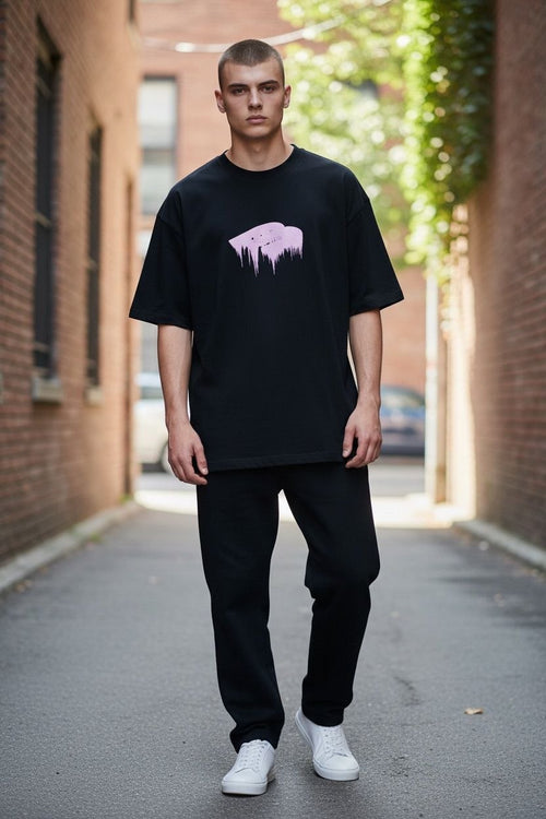 Model wearing an oversized black Balenciaga t-shirt with a glossy pink wet brush logo.