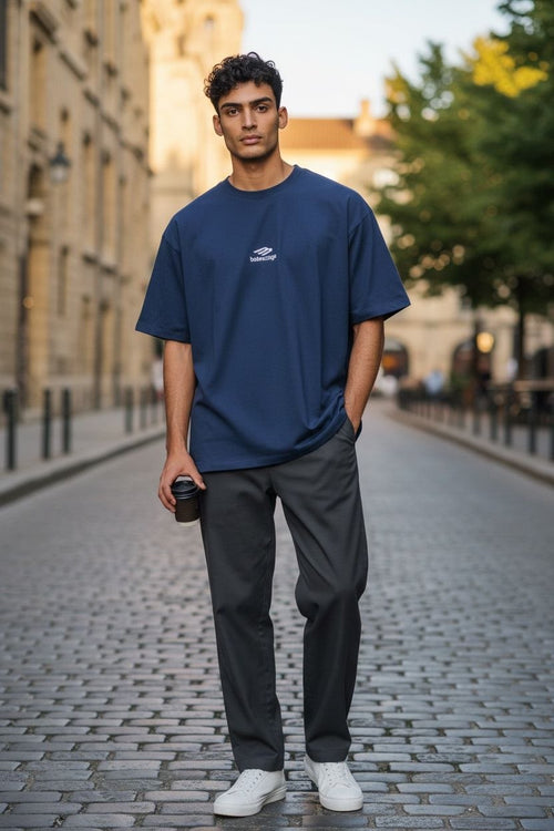 MODEL wearing Front view of navy blue Balenciaga 3B Sports Icon oversized t-shirt with white embroidered logo on chest.