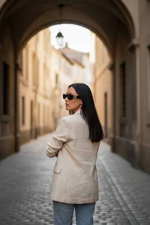 Model wearing black Balenciaga Dynasty rectangle sunglasses with gold BB logos on a city street.