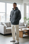 Model wearing an oversized dark grey Fear of God Essentials 90s hoodie.