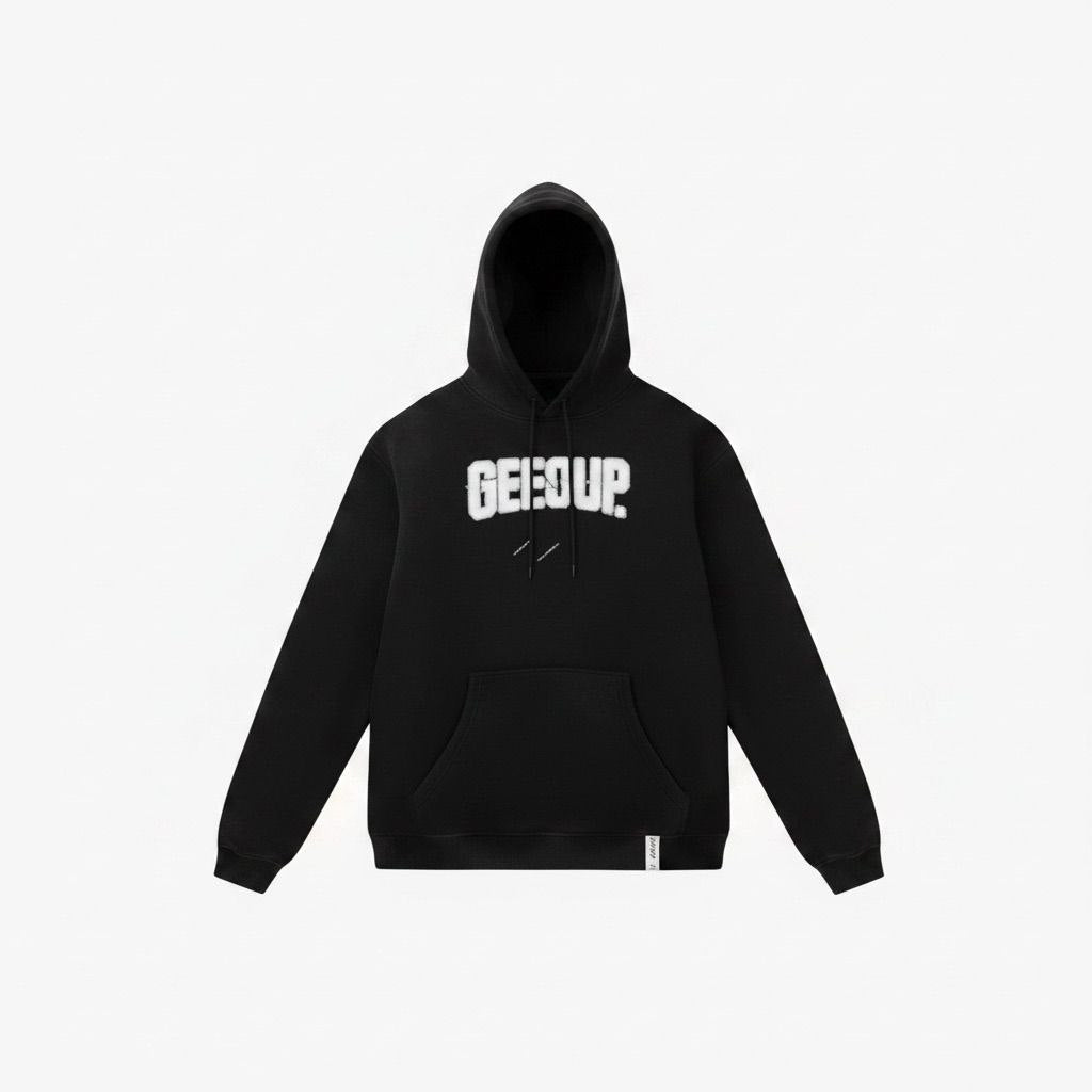 Model wearing an oversized black Geedup Play For Keeps hoodie on a city street.