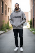 Model wearing an oversized taupe Fear of God Essentials 90s hoodie.