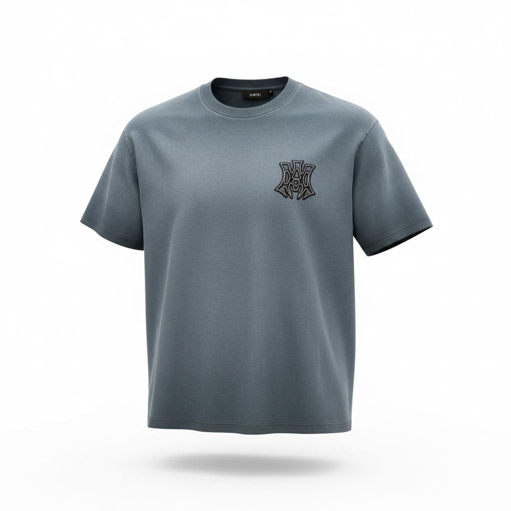 Close-up of the black and white MA monogram logo on a blue Amiri cotton t-shirt.