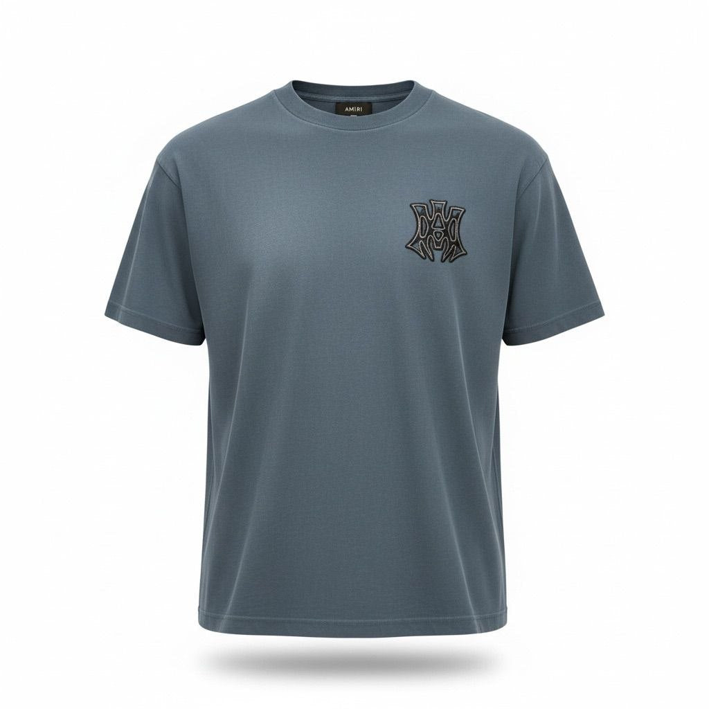 Close-up of the black and white MA monogram logo on a blue Amiri cotton t-shirt.