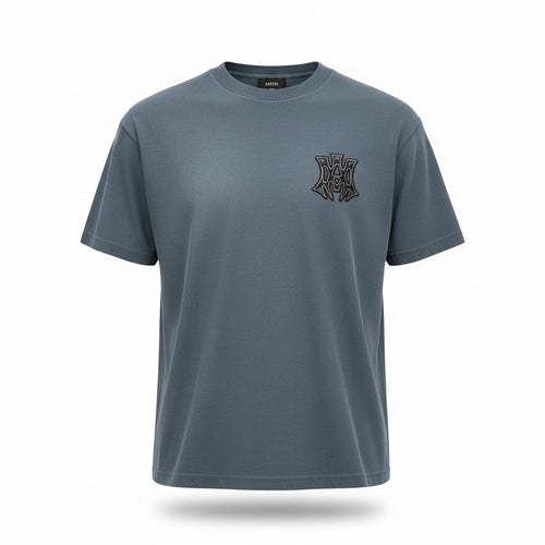 Close-up of the black and white MA monogram logo on a blue Amiri cotton t-shirt.