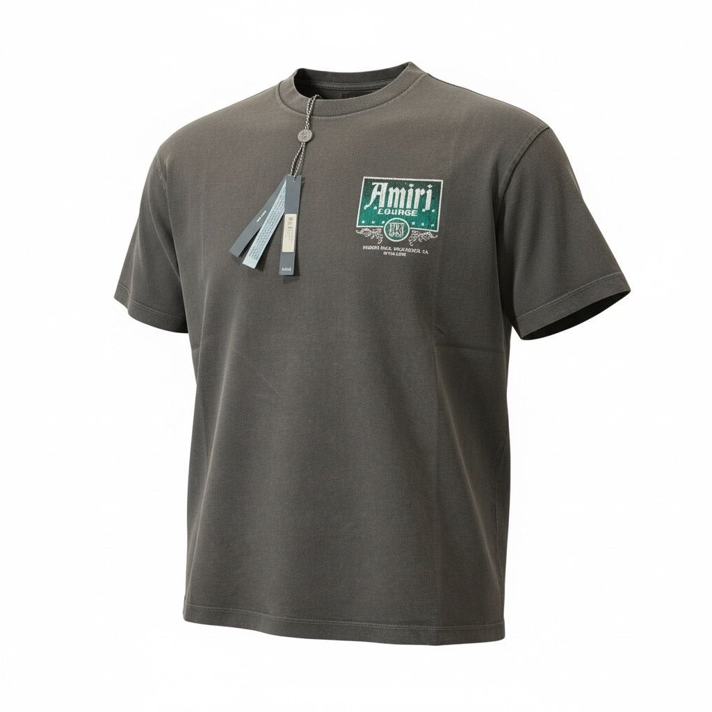 Front view of a charcoal grey AMIRI Lounge t-shirt with a small green and white chest graphic.