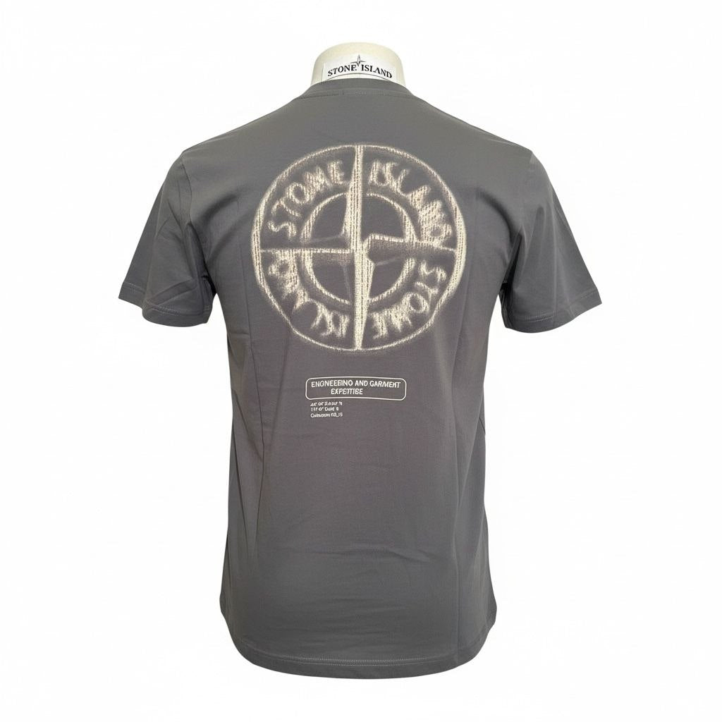 Back view of a charcoal Stone Island t-shirt with a large white compass logo and engineering text.